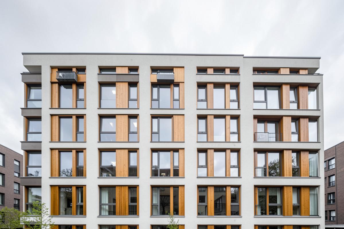 Facciata di un edificio residenziale con finestre in legno-alluminio e rivestimenti verticali in legno chiaro